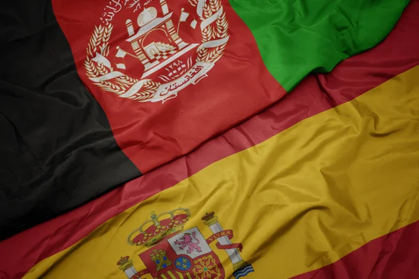 Ondeando colorida bandera de España y bandera nacional de Afganistán . — Foto de Stock