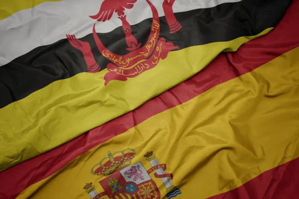 スペインのカラフルな旗とブルネイの国旗を振る. — ストック写真