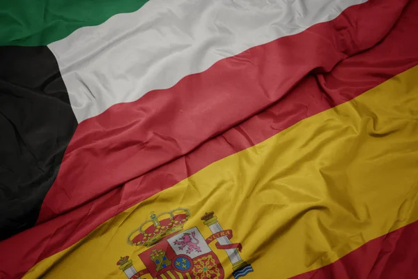 Sventolando bandiera colorata di Spagna e bandiera nazionale di Kuwait . — Foto Stock