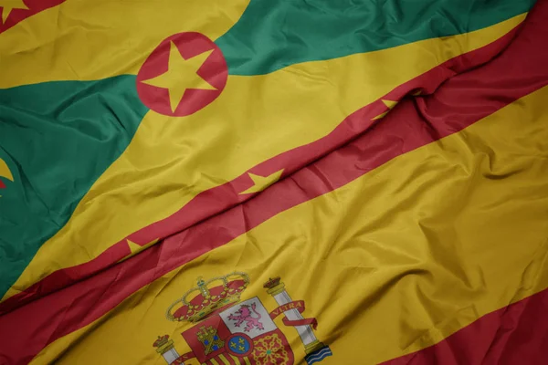 Acenando bandeira colorida de espanha e bandeira nacional de granada . — Fotografia de Stock