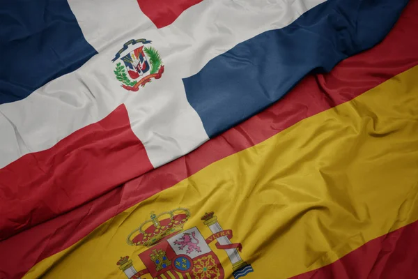 Ondeando colorida bandera de España y bandera nacional de la República Dominicana . —  Fotos de Stock