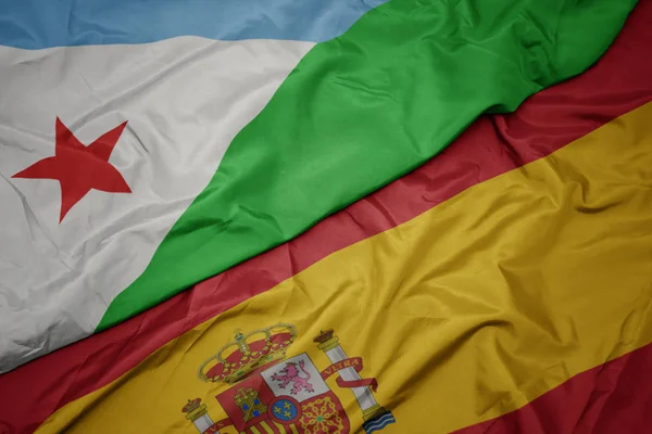 Waving colorful flag of spain and national flag of djibouti. — Stock Photo, Image