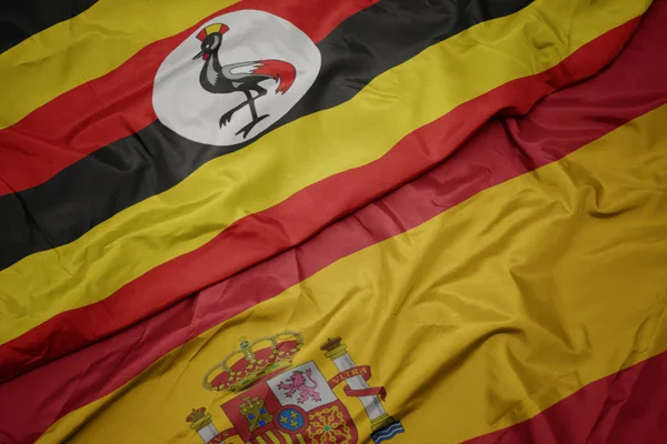 Acenando bandeira colorida de espanha e bandeira nacional de uanabol . — Fotografia de Stock