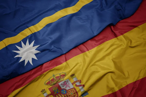 Acenando bandeira colorida de espanha e bandeira nacional de Nauru . — Fotografia de Stock