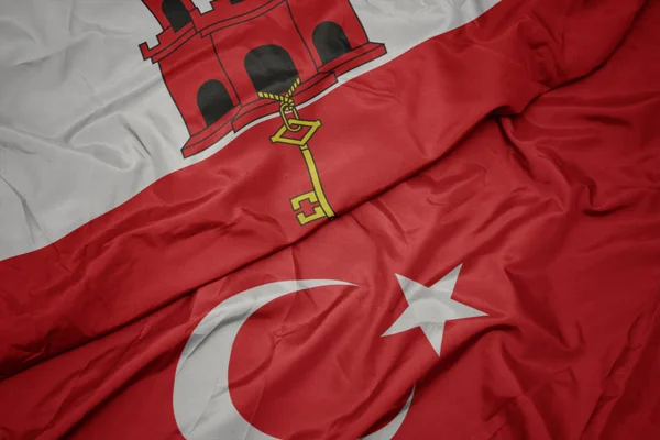 Waving colorful flag of turkey and national flag of gibraltar. — Stock Photo, Image
