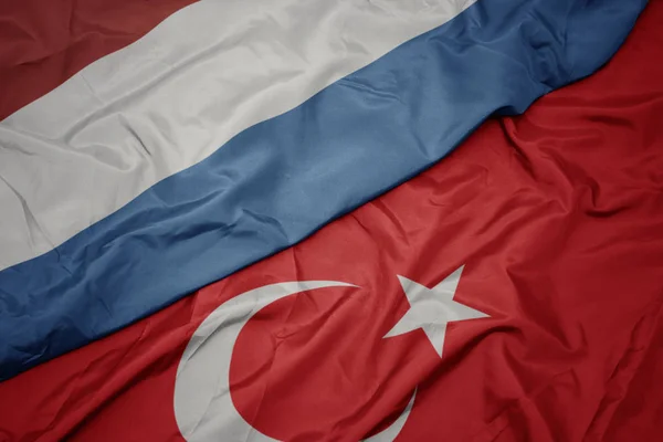 Mávající barvitá vlajka Turecka a státní vlajky Lucemburska. — Stock fotografie