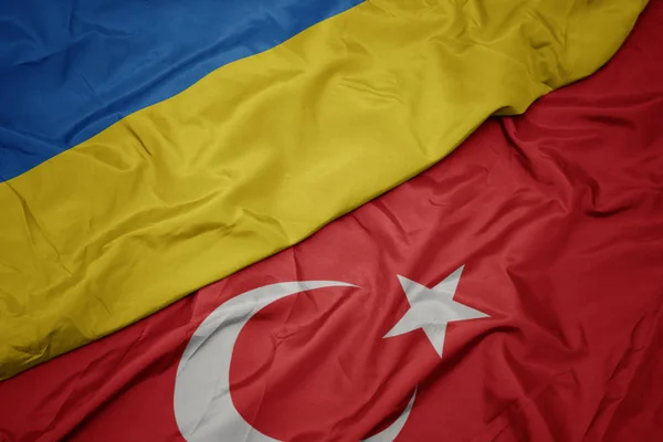 Ondeando colorida bandera de pavo y bandera nacional de Ucrania . — Foto de Stock