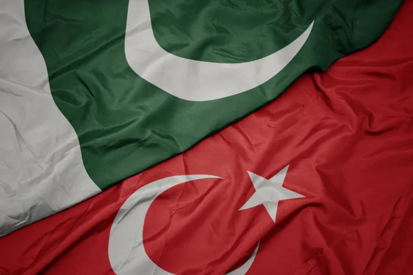 Zwaaiende kleurrijke vlag van Turkije en de nationale vlag van Pakistan. — Stockfoto