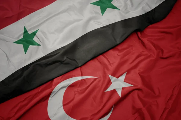 Waving colorful flag of turkey and national flag of syria. — Stock Photo, Image