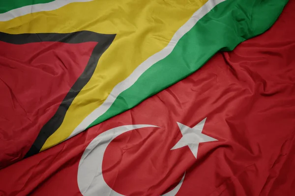 Agitant le drapeau coloré de la dinde et le drapeau national du Guyana . — Photo