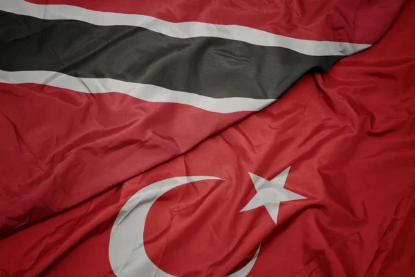 Sventolando bandiera colorata di tacchino e bandiera nazionale di trinidad e tobago . — Foto Stock