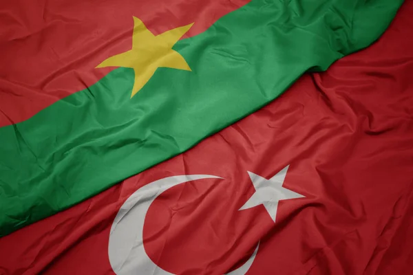 Schwenken bunte Flagge der Türkei und Nationalflagge der Burkina faso. — Stockfoto