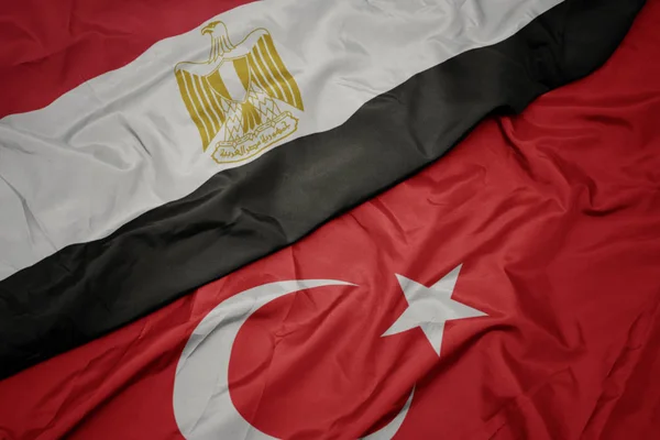 Zwaaiende kleurrijke vlag van Turkije en de nationale vlag van Egypte . — Stockfoto