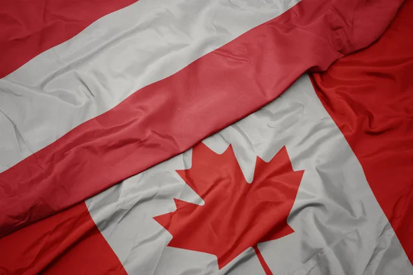 Acenando bandeira colorida do Canadá e bandeira nacional da Áustria . — Fotografia de Stock