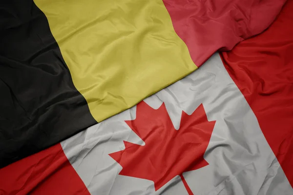 Ondeando colorida bandera de Canadá y bandera nacional de Bélgica . — Foto de Stock