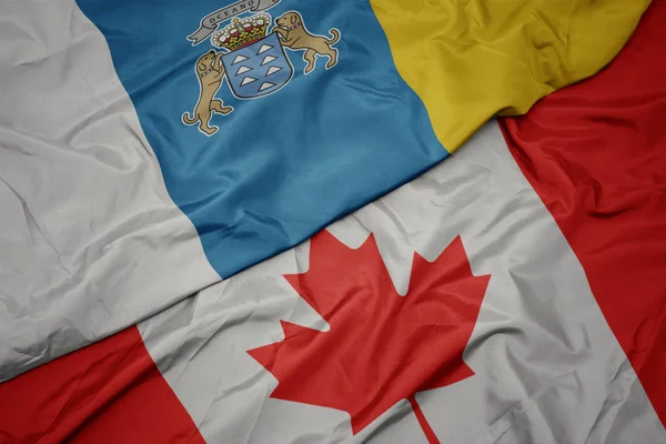 Kanada ve kanarya adalarının ulusal bayrak renkli bayrak sallayarak. — Stok fotoğraf