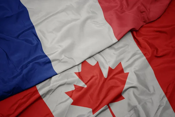 Acenando bandeira colorida do Canadá e bandeira nacional da frança . — Fotografia de Stock