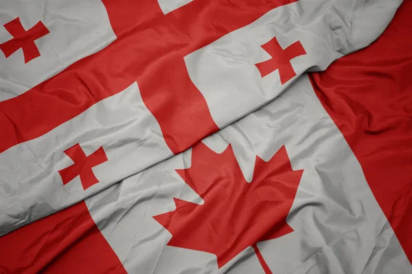 Ondeando colorida bandera de Canadá y bandera nacional de Georgia . —  Fotos de Stock