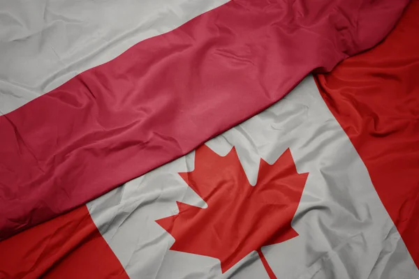 Ondeando colorida bandera de Canadá y bandera nacional de Polonia . —  Fotos de Stock