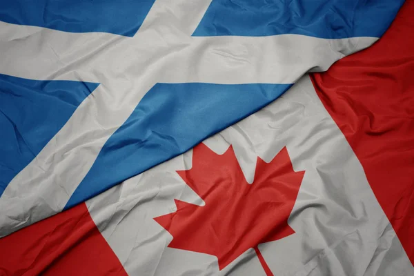 Zwaaiende kleurrijke vlag van Canada en de nationale vlag van Schotland. — Stockfoto