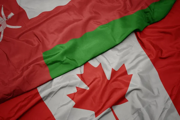 Ondeando colorida bandera de Canadá y bandera nacional de Omán . —  Fotos de Stock