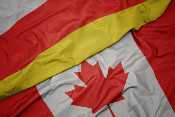 Kanada ve güney osetya ulusal bayrağı renkli bayrak sallayarak. — Stok fotoğraf