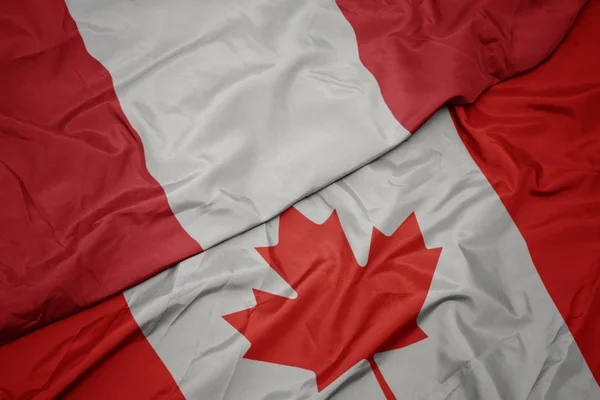 Vinka färgglada flagga av Kanada och nationella flaggan i Peru. — Stockfoto