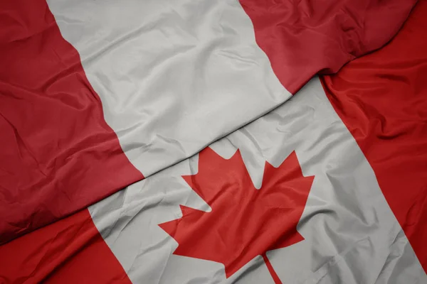 Acenando bandeira colorida do Canadá e bandeira nacional do Peru . — Fotografia de Stock