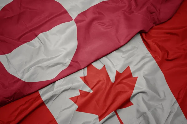 Acenando bandeira colorida do Canadá e bandeira nacional da Groenlândia . — Fotografia de Stock