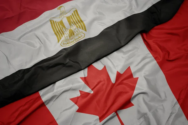 Zwaaiende kleurrijke vlag van Canada en de nationale vlag van Egypte . — Stockfoto