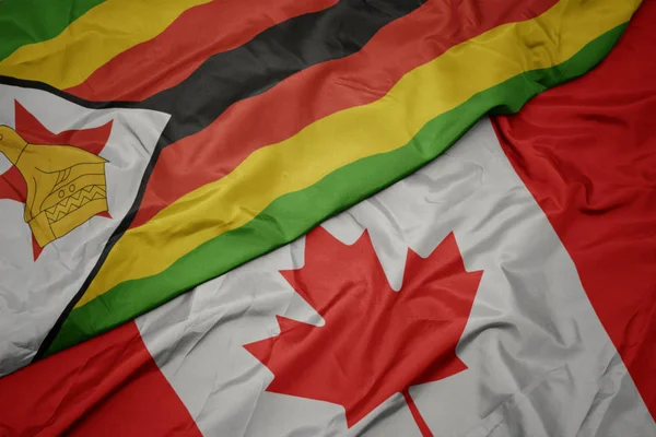 Agitant drapeau coloré du Canada et drapeau national de zimbabwe . — Photo