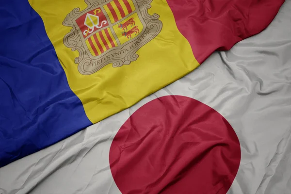 waving colorful flag of japan and national flag of andorra.