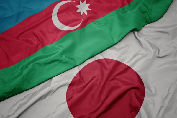 waving colorful flag of japan and national flag of azerbaijan.