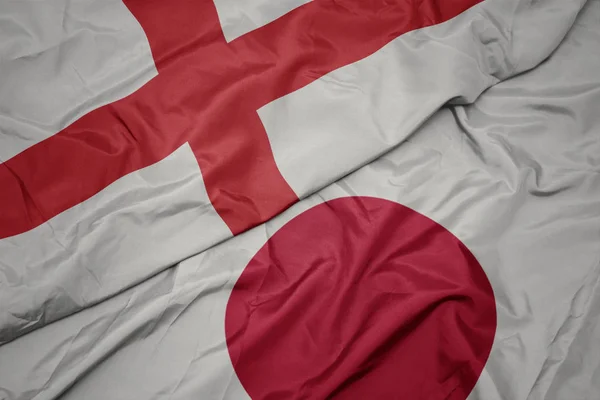 waving colorful flag of japan and national flag of england.