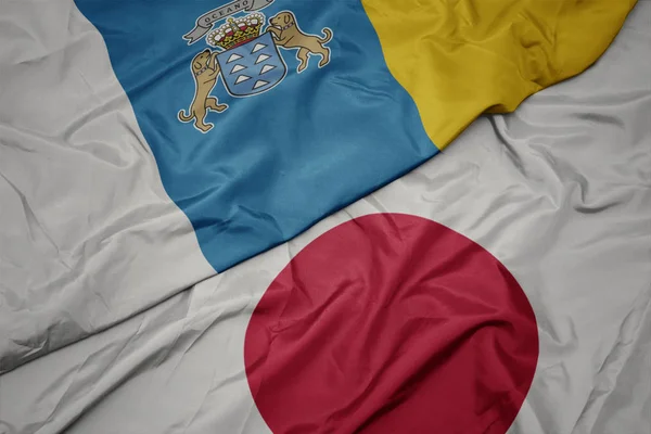 Sventolando bandiera colorata del Giappone e bandiera nazionale delle isole canarie . — Foto Stock
