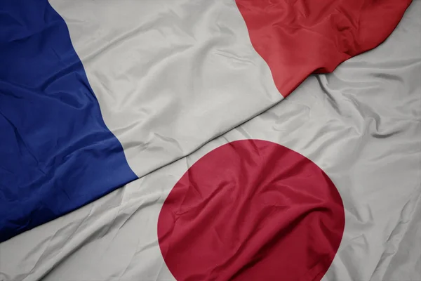 Ondeando colorida bandera de Japón y bandera nacional de Francia . —  Fotos de Stock