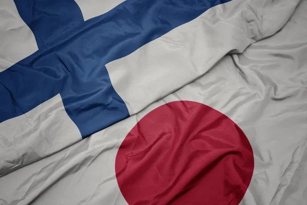 Размахивая красочным флагом Японии и национальным флагом Финляндии . — стоковое фото