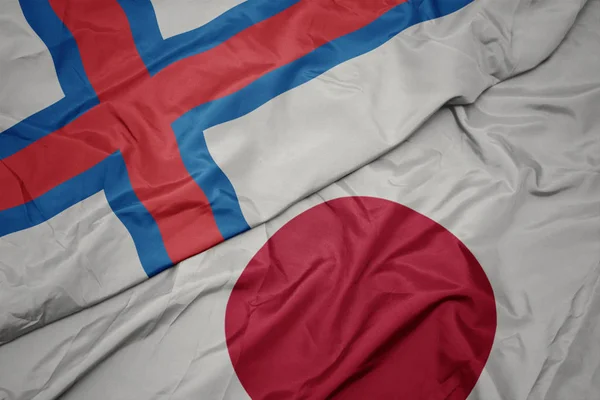 waving colorful flag of japan and national flag of faroe islands.