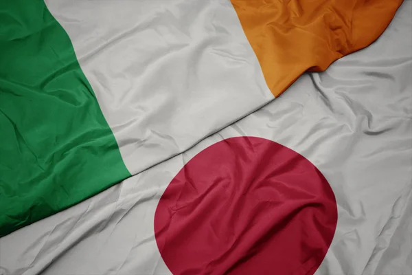 waving colorful flag of japan and national flag of ireland.