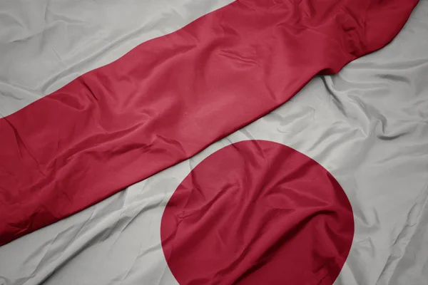 Mávající barevná vlajka Japonska a národní vlajky Polska. — Stock fotografie
