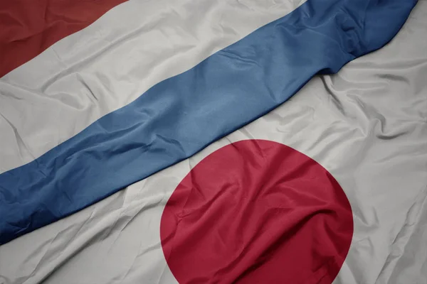 Mávající barevná vlajka Japonska a Lucemburské vlajky. — Stock fotografie