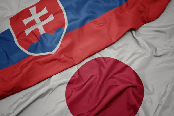 waving colorful flag of japan and national flag of slovakia.