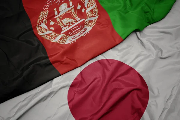 Ondeando colorida bandera de Japón y bandera nacional de Afganistán . — Foto de Stock