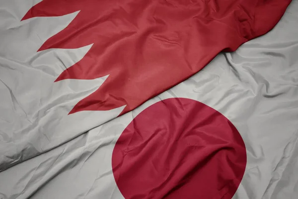 waving colorful flag of japan and national flag of bahrain.