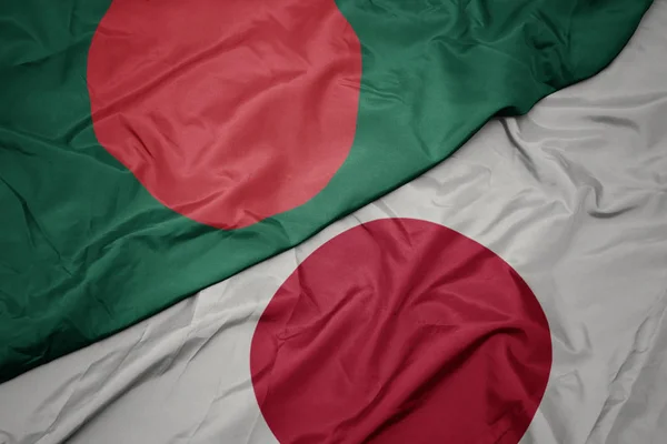 Falujące kolorowe flagi Japonii i flagi narodowej Bangladeszu. — Zdjęcie stockowe