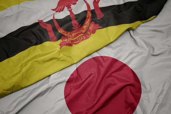 waving colorful flag of japan and national flag of brunei.