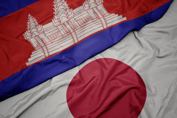 waving colorful flag of japan and national flag of cambodia.