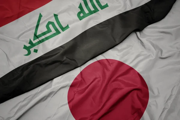 waving colorful flag of japan and national flag of iraq.