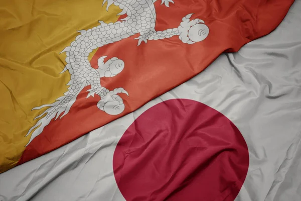 waving colorful flag of japan and national flag of bhutan.