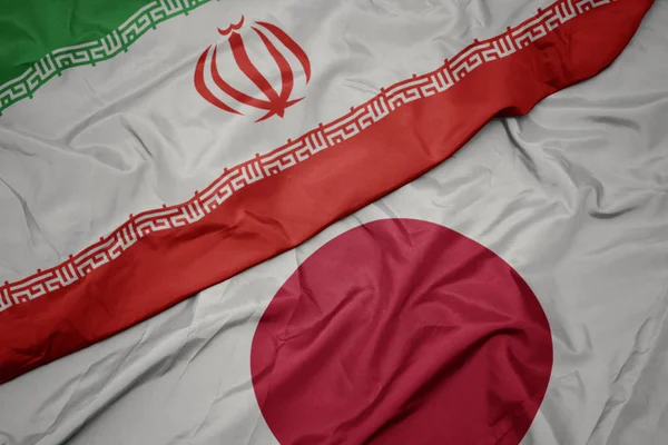 Agitant drapeau coloré du Japon et drapeau national de l'iran . — Photo